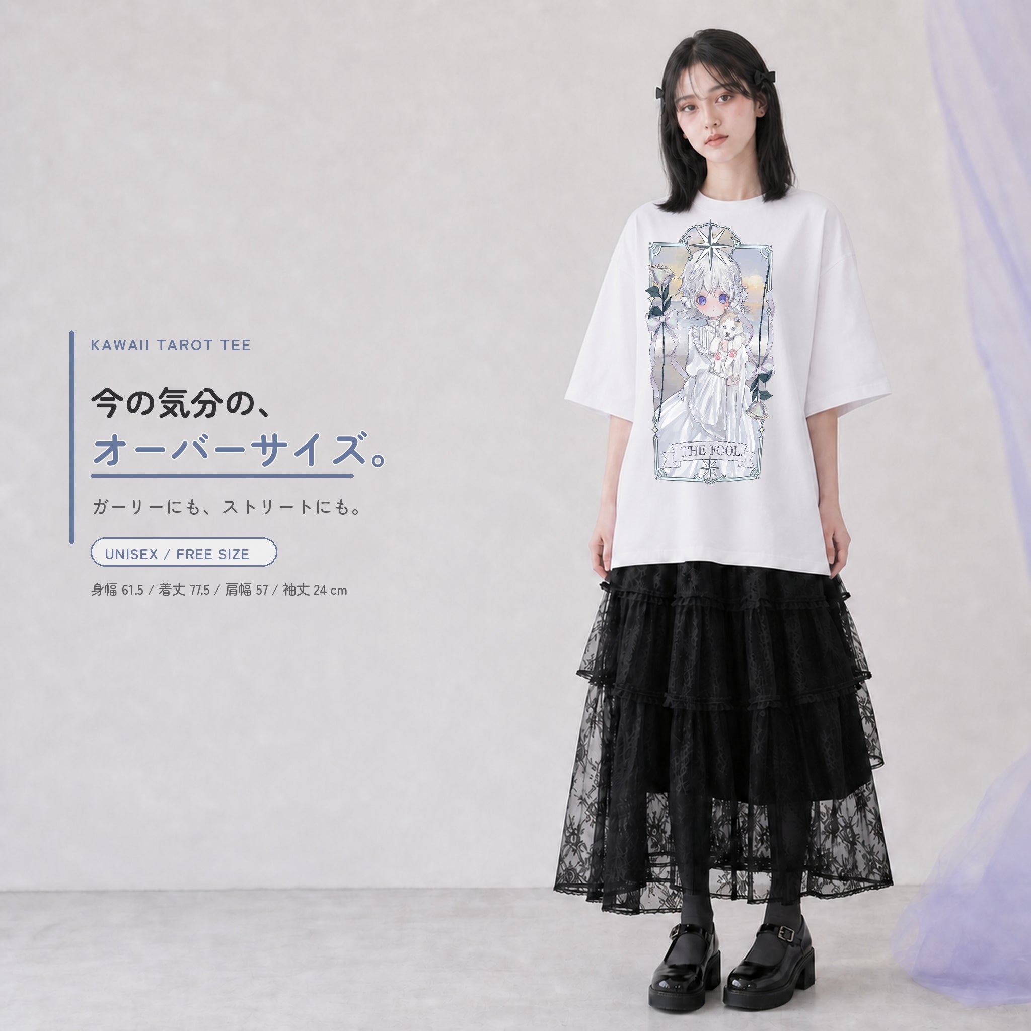 THE FOOL柄の白いオーバーサイズTシャツを、若い女性がロング丈のスカートと合わせた全身コーディネート。