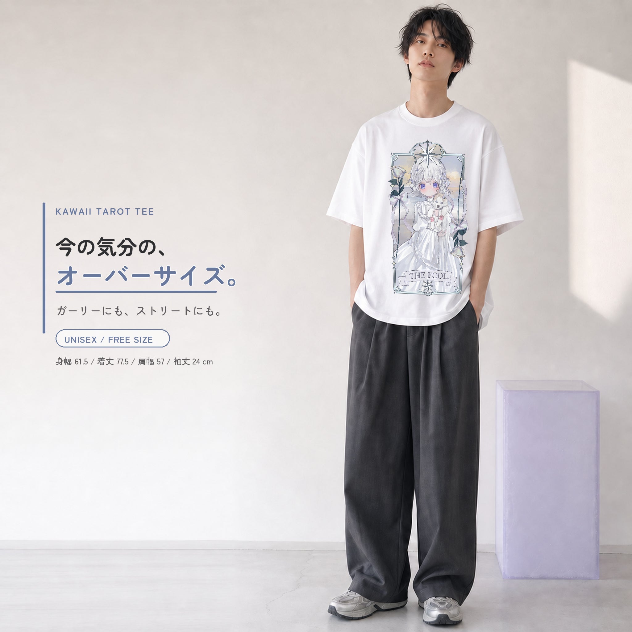 THE FOOL柄の白いオーバーサイズTシャツを、若い男性がワイドパンツと合わせたユニセックスコーディネート。