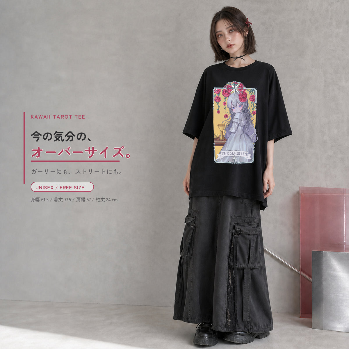 THE MAGICIAN柄の黒いオーバーサイズTシャツを、若い女性がカーゴロングスカートと合わせたコーディネート。